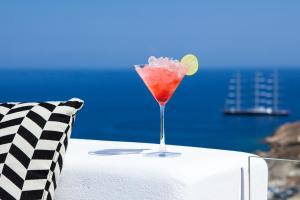 a drink in a glass sitting on top of a table at Amyth of Mykonos Super Paradise in Super Paradise Beach