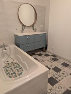 a bathroom with a tub and a sink and a mirror at Villa moderne, piscine & plage in Lattes