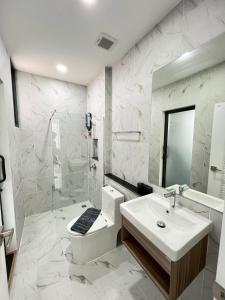 a bathroom with a toilet and a sink and a shower at Emmaree Villa in Ban Chong Phli