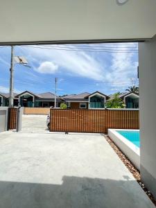 a house with a fence and a swimming pool at Emmaree Villa in Ban Chong Phli