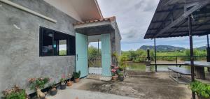 a house with a blue door and a balcony with flowers at A small house next to the canal in Prachuap Khiri Khan
