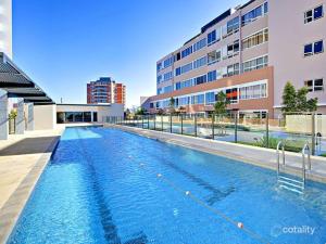 a large swimming pool in front of a building at Modern Comfort Hurstville 2BR Wifi Train Business in Sydney