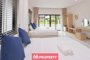 ein Schlafzimmer mit 2 Betten und ein Schild, auf dem steht: in der Unterkunft Minimalist Modern Home, Smart TV, Kitchen in Chiang Mai