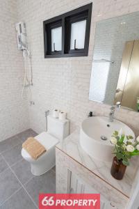 ein Badezimmer mit Waschbecken, Toilette und Spiegel in der Unterkunft Minimalist Modern Home, Smart TV, Kitchen in Chiang Mai + 24 Fotos