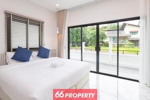 ein Schlafzimmer mit einem weißen Bett und einem großen Fenster in der Unterkunft Minimalist Modern Home, Smart TV, Kitchen in Chiang Mai
