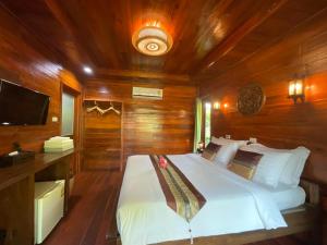 a bedroom with a white bed in a wooden room at Siam Lanta Resort - SHA Extra Plus in Ko Lanta