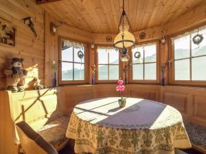 a dining room with a table and some windows at Chalet on the slopes in Piesendorf
