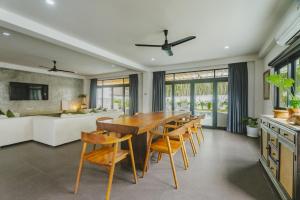 a dining room with a large wooden table and chairs at Eden Villa A Tropical Paradise Pool Villa in Rawai Beach