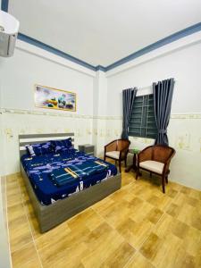 a bedroom with a bed and two chairs at Hoàng Gia 2 Motel Long An in Ðức Hòa