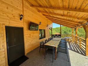 a wooden cabin with a table and chairs on a patio at Chalet Valisoara Cluj in Vălisoara