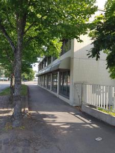 a building with a tree next to a street at Kouvolankatu Studio in Kouvola
