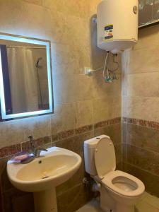 ein Badezimmer mit Toilette, Waschbecken und Spiegel in der Unterkunft Coral Hills Resort North Coast Amazing place in Jalāl