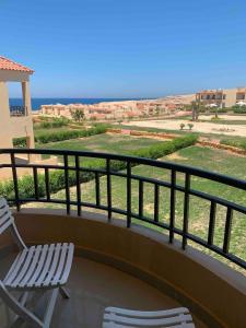2 Stühle auf einem Balkon mit Meerblick in der Unterkunft Coral Hills Resort North Coast Amazing place in Jalāl