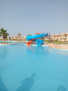 eine blaue Wasserrutsche in einem großen Schwimmbecken in der Unterkunft Coral Hills Resort North Coast Amazing place in Jalāl
