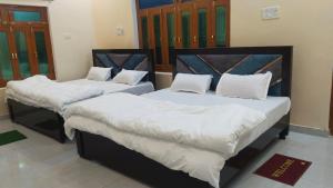 Giường trong phòng chung tại OM Palace Guest House-Fully Air Conditioned