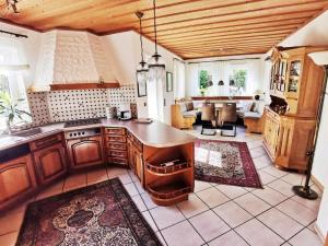 a kitchen with wooden cabinets and a living room at Ferienwohnung Catus in Rheinzabern