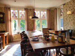 une salle à manger avec une grande table et des chaises en bois dans l'établissement Hotel Stedswal, à Sloten