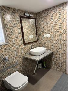 a bathroom with a sink and a toilet at Phalguni Farm Stay in Nanjangūd