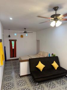 a bedroom with a couch and a ceiling fan at Phalguni Farm Stay in Nanjangūd