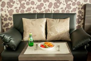 a bowl of food and a drink and a bowl of fruit on a couch at BON Condominium Namba Ebisu in Osaka