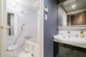 a bathroom with a sink and a toilet and a shower at BON Condominium Namba Ebisu in Osaka