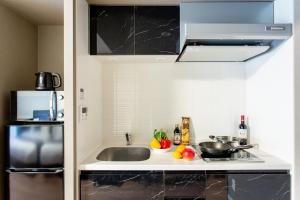 a small kitchen with a sink and a refrigerator at BON Condominium Namba Ebisu in Osaka