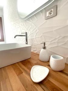 a bathroom with a sink and two toilets on a wooden floor at Luxi Apartment Teulada in Teulada