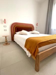 a bedroom with a large bed with a wooden frame at Luxi Apartment Teulada in Teulada