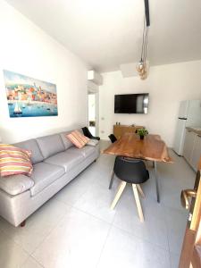 a living room with a couch and a wooden table at Luxi Apartment Teulada in Teulada