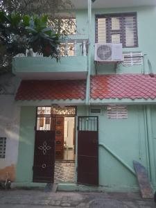 uma casa com duas portas e um telhado vermelho em Sai Home Stay em Pondicherry