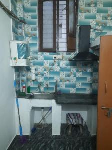uma casa de banho com um lavatório e uma parede azul em Sai Home Stay em Pondicherry