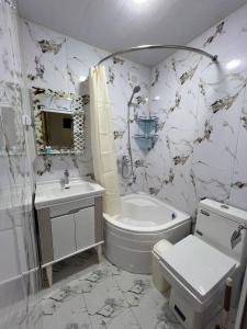 Un baño con bañera, inodoro y lavabo. en Zardozon Hotel, en Bukhara