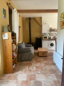 a living room with a couch and a kitchen at Maisonnette de campagne 70m2 in Lartigue +10 photos