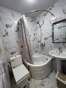 a bathroom with a tub and a sink and a toilet at Zardozon Hotel in Bukhara +23 photos