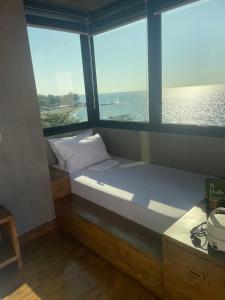 a small room with a bed and two windows at A-Lofts Sky Suite amazing beachfront 360 sea view in San Juan