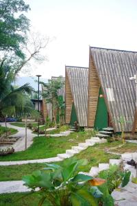 una casa con un tetto grigio e alcune piante di Angsavanh Resort a Vang Vieng