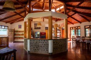 a restaurant with a counter in the middle of a room at Kilimanjaro Lodge - MCF in Moshi