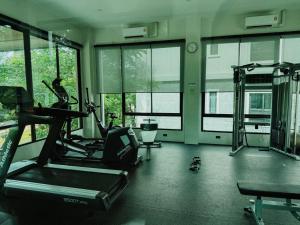 a gym with treadmills and ellipticals in a room with windows at FAMILY HOMES Halo - Brand New 2BDRM Poolside Apartment in Phuket +16 photos