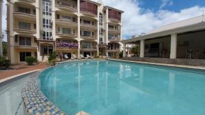 a swimming pool in front of a building at Residence Les Peupliers 05-06 in Flic-en-Flac