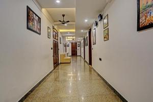 a hallway with white walls and paintings on the walls at Hotel O Golden Eye Inn in New Delhi