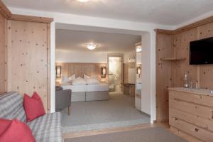 a hotel room with a bed and a television at Landhaus Sepp Santer in Sölden