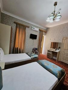 a hotel room with two beds and a tv at SaraSofi Hotel in Baku