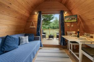 a room with a couch and a table in a cabin at Lakeside Haven -Fishing Lakes, Heated Outdoor Swimming Pool 500yrds on Sister Park , Pool Open May to September in Cheriton Bishop