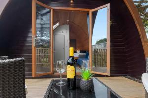 a bottle of wine and two glasses on a table at Lakeside Haven -Fishing Lakes, Heated Outdoor Swimming Pool 500yrds on Sister Park , Pool Open May to September in Cheriton Bishop +18 photos
