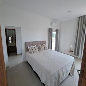 a white bedroom with a bed and a window at Residencial Náutico in Paraipaba +35 photos