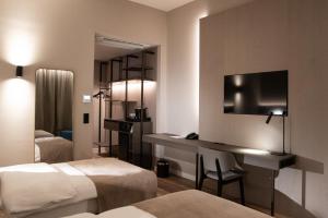 a hotel room with two beds and a desk with a television at Balaton Park Hotel in Balatonfőkajár