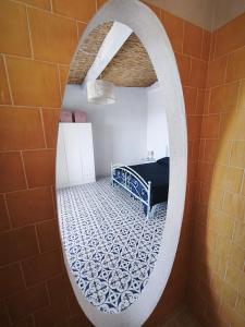 a bathroom with a mirror and a bed in a room at Circe in Capo Vaticano +5 photos