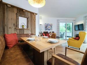 a living room with a wooden table and yellow chairs at Chalet in Sankt Johann near Ski Slopes in Alpendorf +17 photos