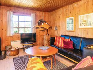 a living room with a blue couch and a table at 6 person holiday home in Rømø in Bolilmark
