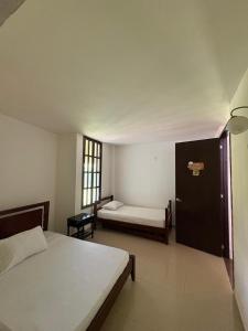a bedroom with two beds and a door with a window at Hotel Campestre Jardín del Café Quindío in Armenia +33 photos